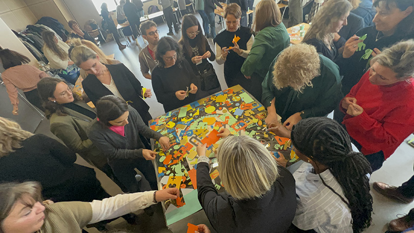 Les participantes au team building de la fresque de la considération My Art Box à Saint Etienne sont massées autour du plexi pour coller leurs réponses personnelles